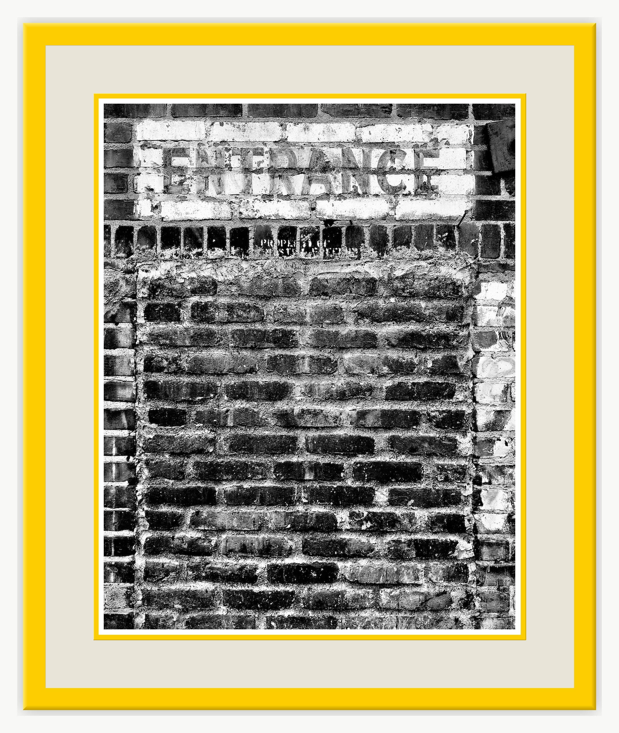 tractor & entrance at TAG Gallery The photograph shows a weathered brick wall with a rectangular sign above.