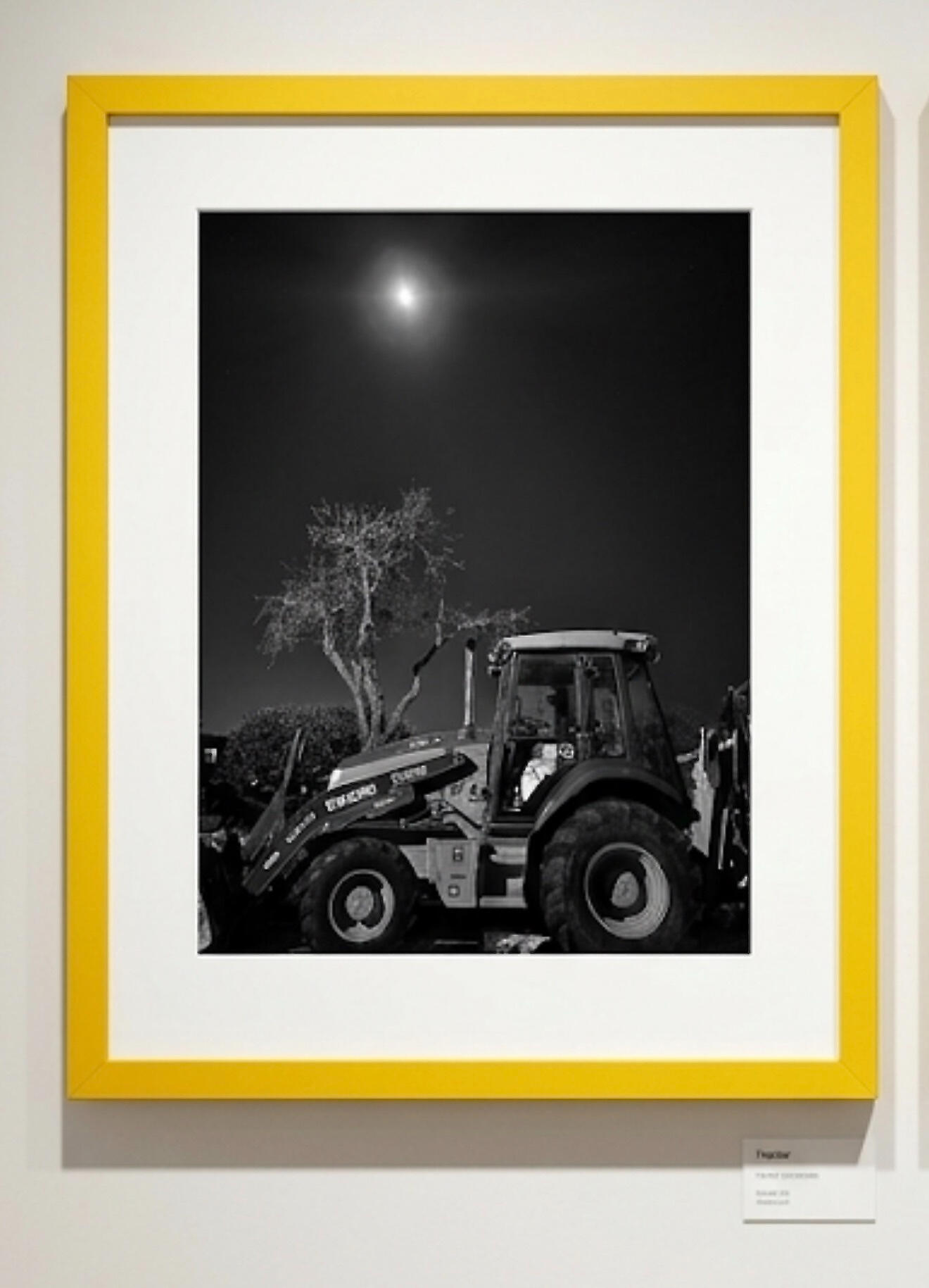 tractor & entrance at TAG Gallery The photograph shows a weathered brick wall with a rectangular sign above.