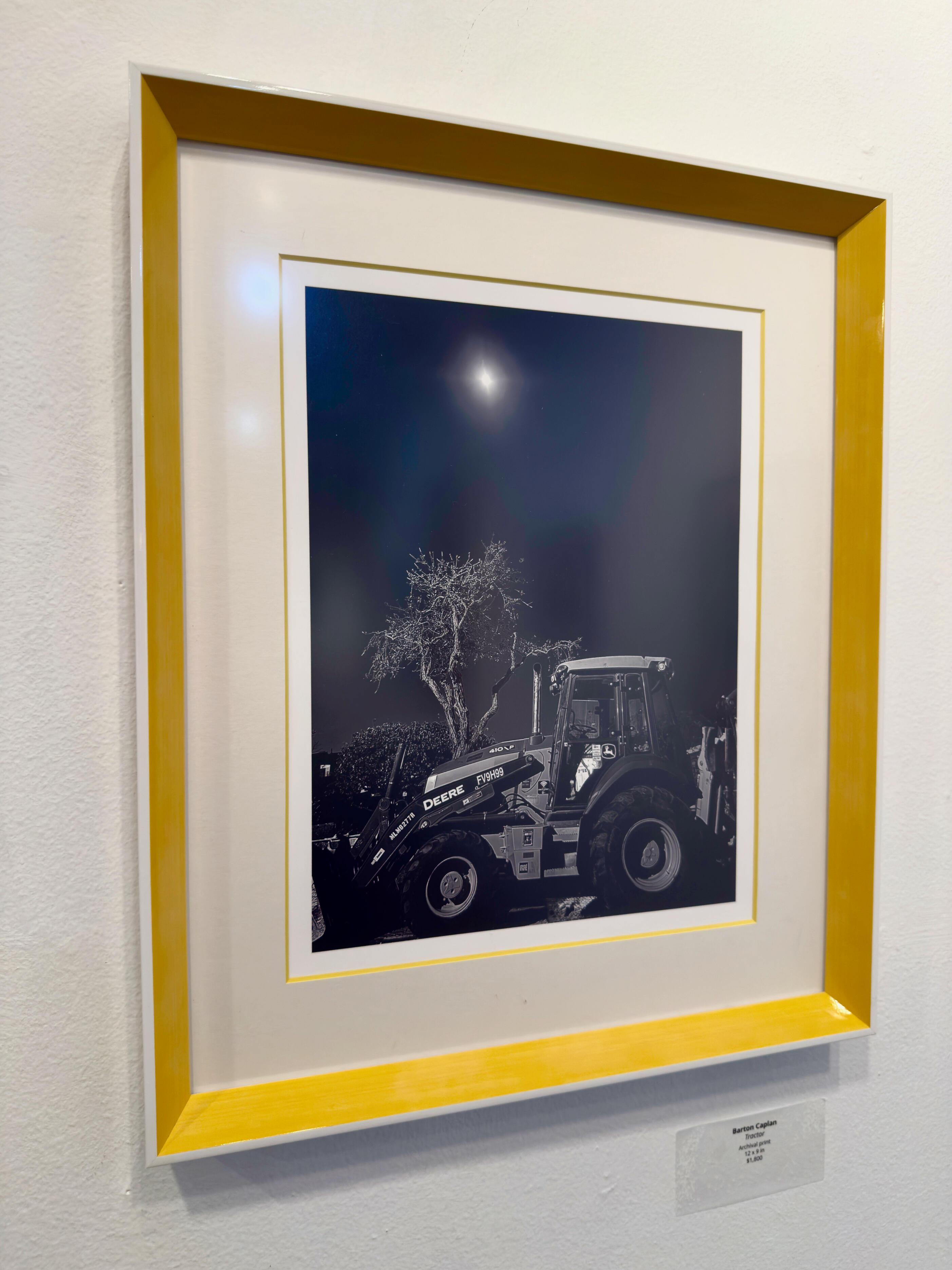 tractor & entrance at TAG Gallery The photograph shows a weathered brick wall with a rectangular sign above.